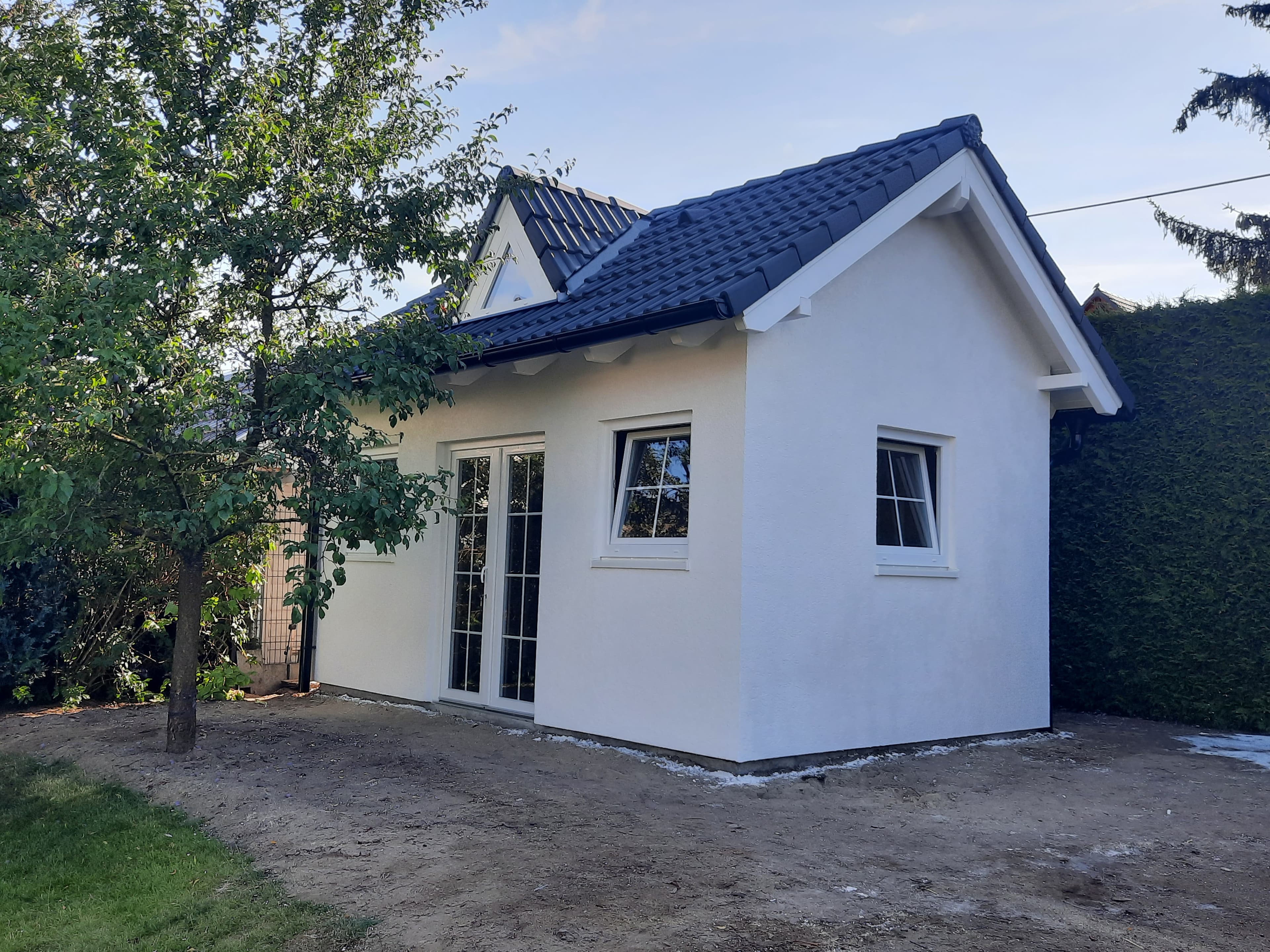 Weißes Gartenhaus mit Pultdach und Terrassentür