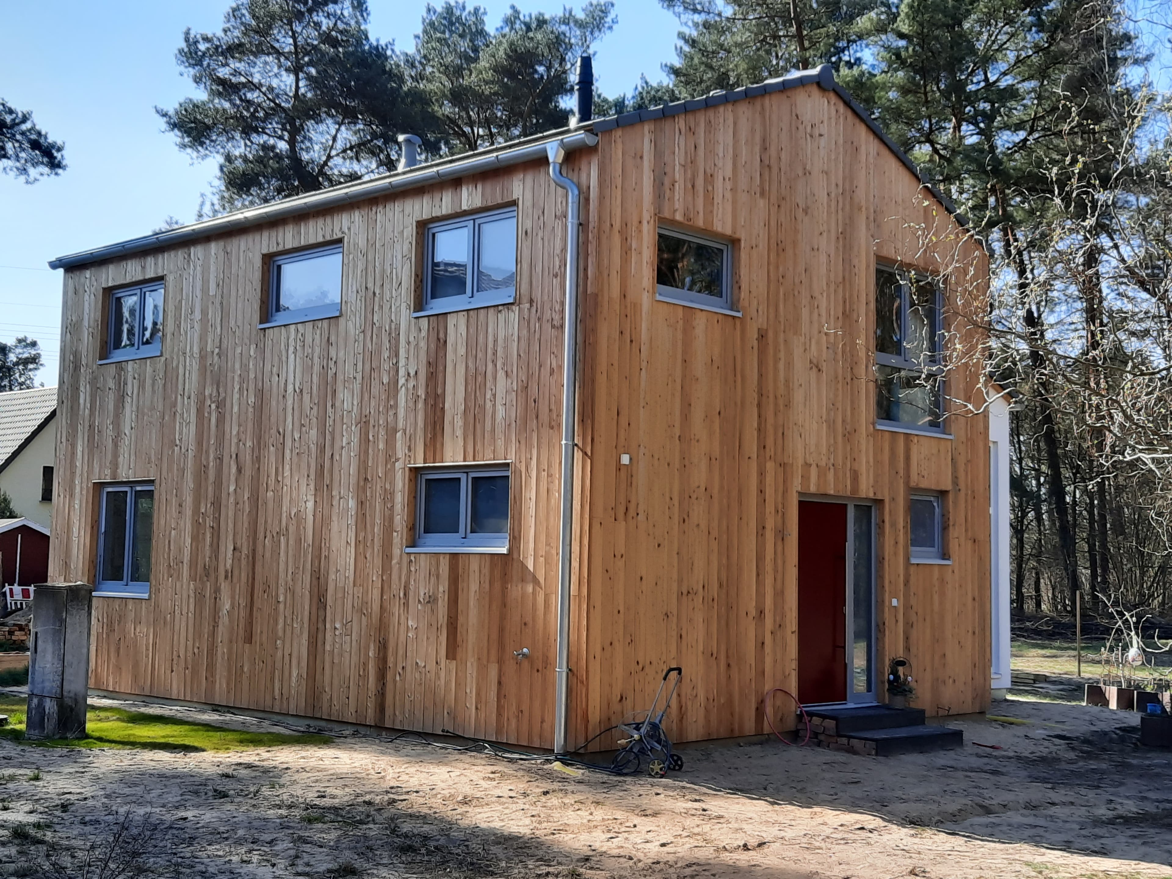 Einfamilienhaus mit Lärchenholzfassade zwischen Kiefern