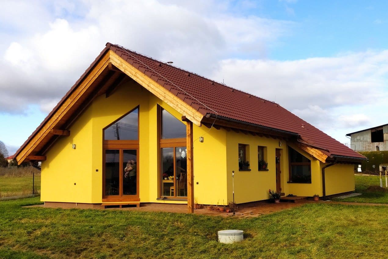 Gelbes Haus mit rotem Ziegeldach und verglastem Giebel