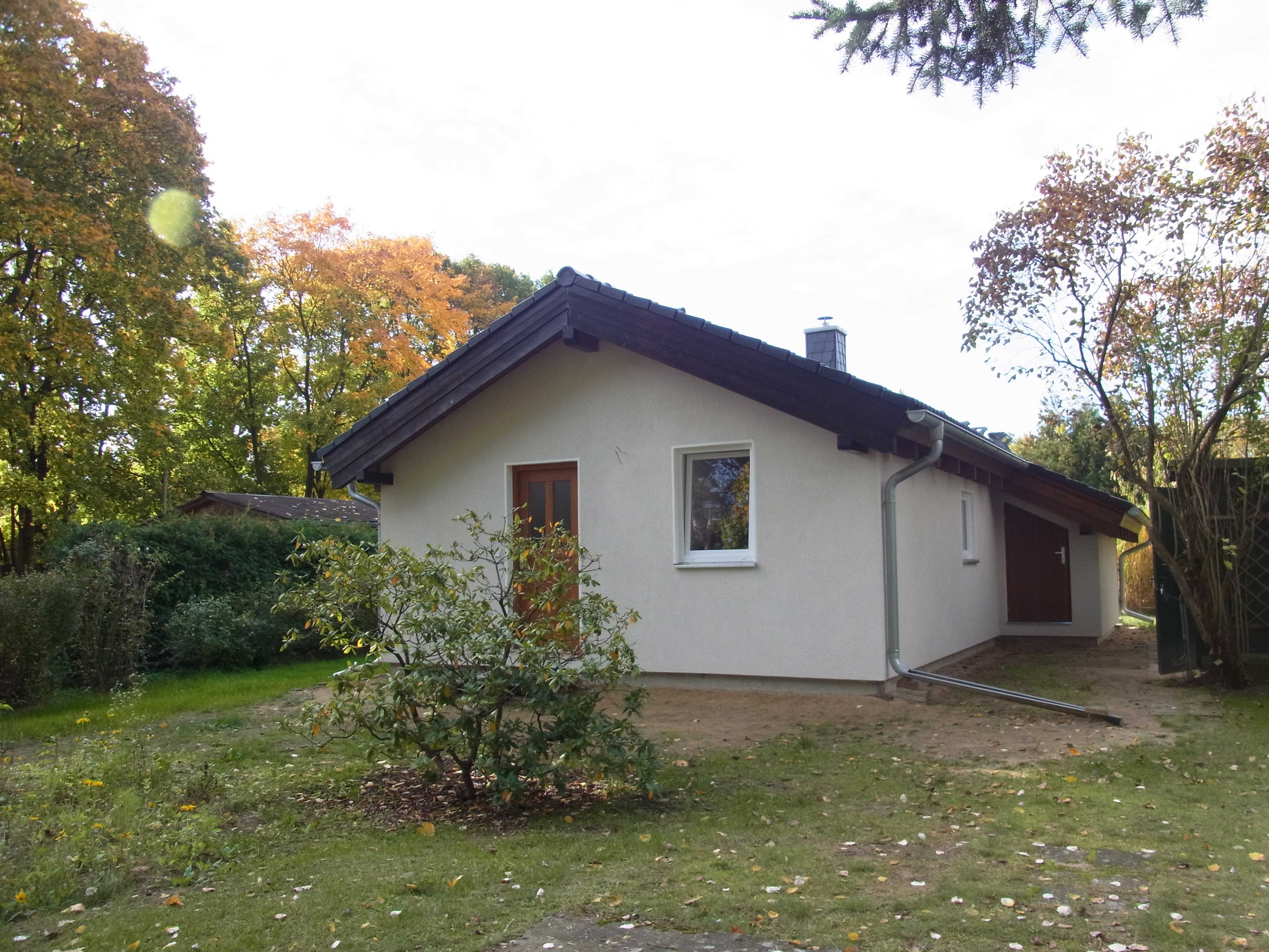 Bungalow mit Holzgiebel auf dem fertigen Grundstück im Herbst